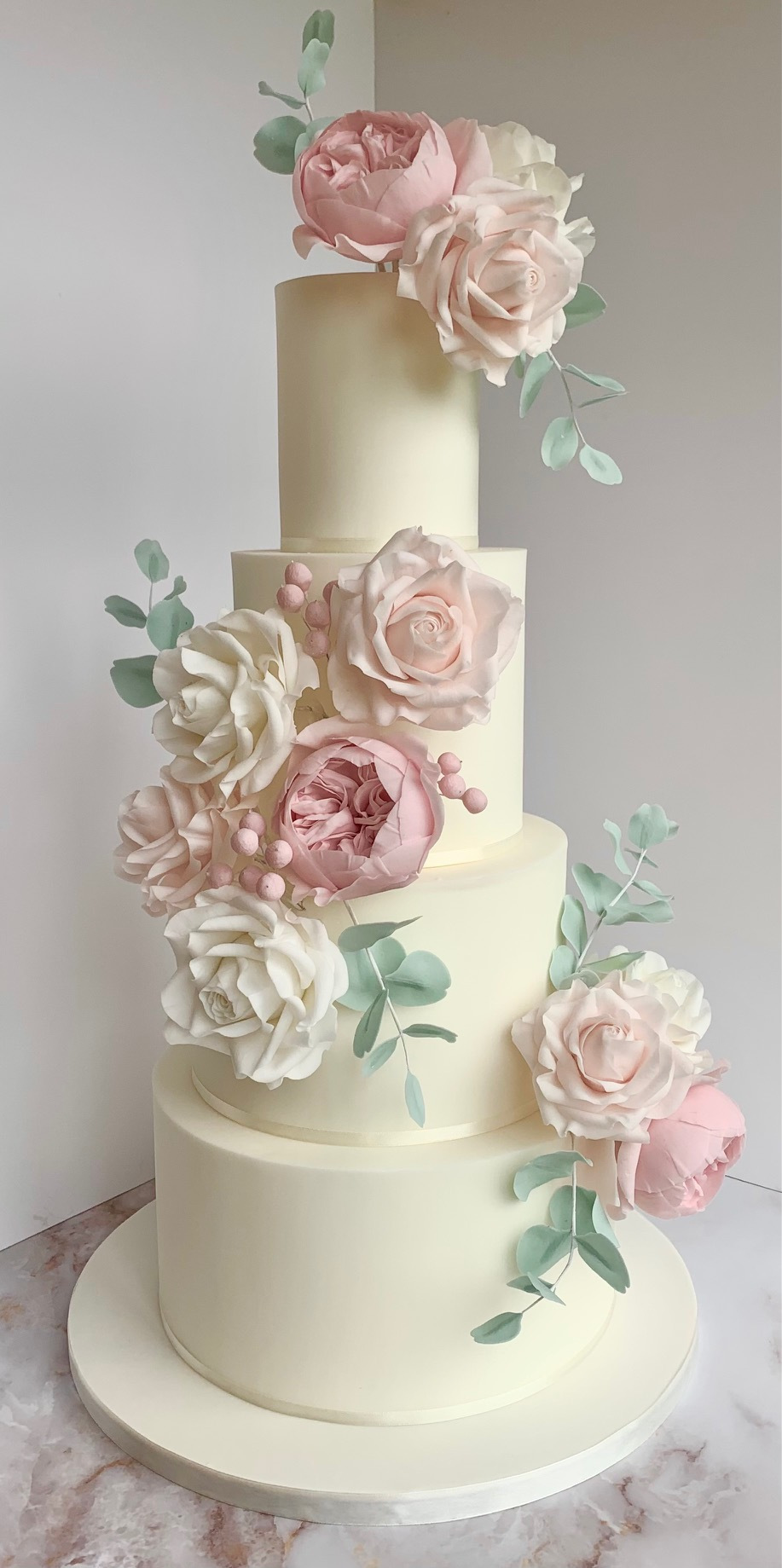 4 tiered wedding cake with a pale pink color scheme of sugar flowers